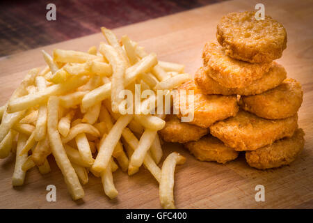 Golden braun Chicken Nuggets und Pommes Frites auf Holz Hintergrund Stockfoto