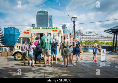 Leute, die sich vor einem Eiswagen neben dem London Bridge City Pier an der Themse in London, England, Großbritannien anstellen Stockfoto