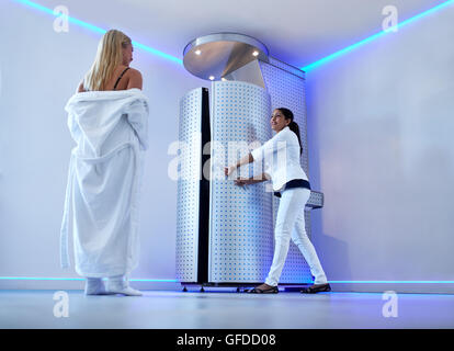 In voller Länge Portrait von Frau im Bademantel Klinik Kosmetik Kryotherapie Behandlung in Kryosauna anstreben. Krankenschwester am Stockfoto