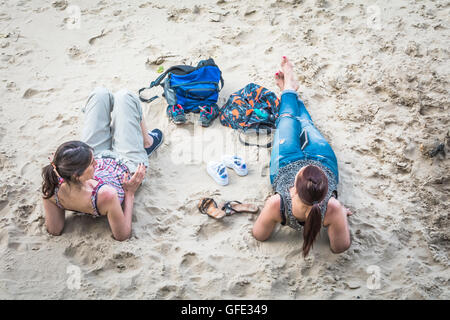 Zwei Frauen, Sonnenbaden am Strand auf der Londoner Southbank Stockfoto