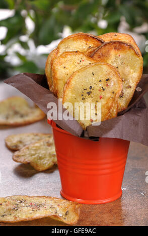 Hausgemachte Kartoffelchips in Papier eingewickelt und gefaltet Eimer Stockfoto