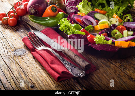 Frühlingssalat mit saftigen Gemüse auf einem rustikalen Holztisch. Stockfoto