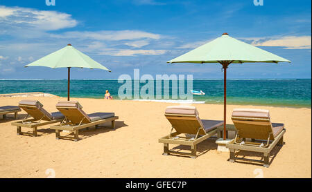 Liegestühle mit Sonnenschirm am Strand von Sanur, Bali, Indonesien Stockfoto