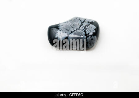 Ausschnitt aus einer Schneeflocke Obsidian Edelstein auf weißem Hintergrund Stockfoto