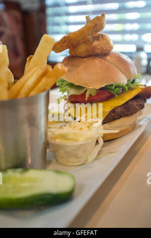 Cheeseburger auf einem Vollkorn-Brötchen mit Steak Pommes Frites auf der Seite Stockfoto