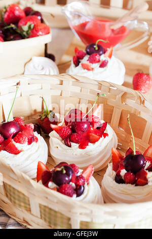 Mini Pavlova Baiser Torte dekoriert mit frischen Erdbeeren und Kirschen Stockfoto