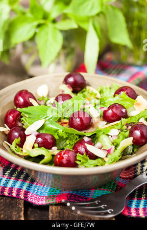 Sommer grüner Salat mit frische Kirschen, Mandeln und Vinaigrette-dressing Stockfoto