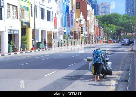 Eine Frau sammelt Kartons für das Leben in Chinatown Singapur. Stockfoto