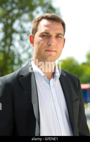 Close-up Portrait des jungen Geschäftsmann in einen dunklen Anzug und weißem Hemd auf dem Hintergrund der Sommer Stadt Stockfoto