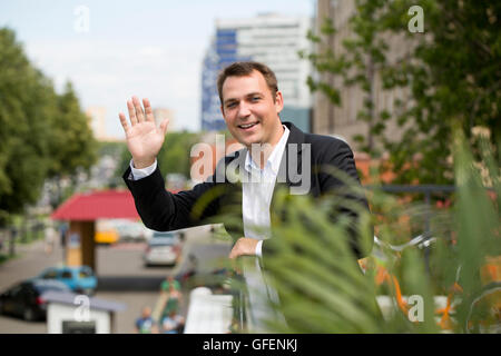 Close-up Portrait des jungen Geschäftsmann in einen dunklen Anzug und weißem Hemd auf dem Hintergrund der Sommer Stadt Stockfoto