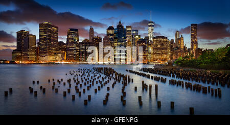 Panorama von Lower Manhattan Financial District in der Dämmerung mit alten Pier hölzerne Pfähle und World Trade Center. New York City Stockfoto