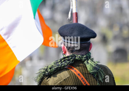 Ein Mann in paramilitärischen Uniform, mit einer irischen Trikolore wie Er erinnert an den Osteraufstand von 1916 Stockfoto