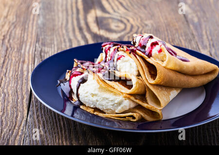 Hausgemachte Crepes mit Frischkäse, Schokolade und Berry sauce topping Stockfoto