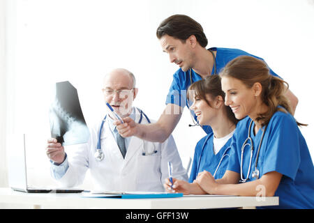 Ärzteteam Kontrolle über Röntgenergebnisse isoliert auf weiss Stockfoto