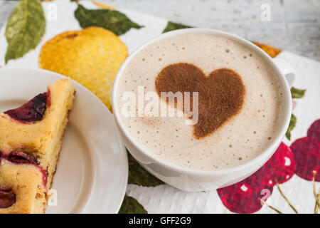 Kuchen mit Pflaumen und eine Tasse Kaffee und Herz. Stockfoto