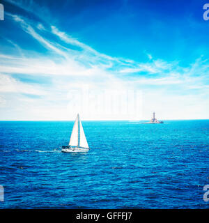 Weiße Yacht segeln in Ruhe tiefblaues Meer. Leuchtturm. Stockfoto