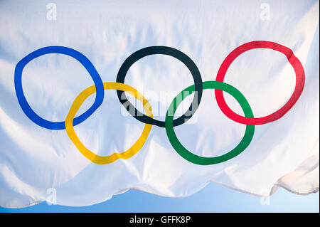 RIO DE JANEIRO - 27. März 2016: Eine olympische Fahne flattert im Wind gegen strahlend blauen Himmel. Stockfoto