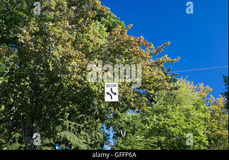 Begin zwei weg drehen Schild mit Bäumen und blauen Himmel Stockfoto