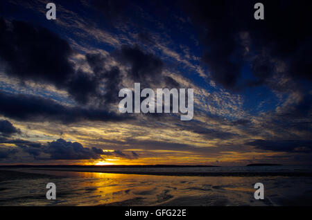 Sonnenuntergang am Penmaenmawr Beach in Richtung Anglesey Stockfoto