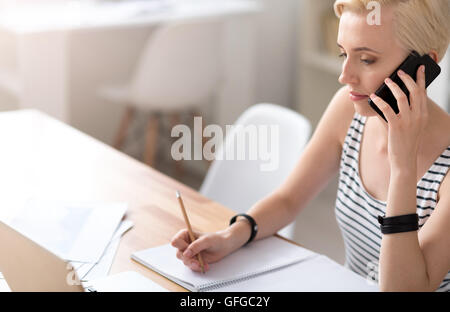 Frau, Notizen und sprechen auf smartphone Stockfoto