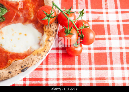 Detail einer echten italienischen Pizza in Neapel mit Ciliegini Tomaten Stockfoto