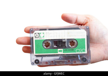 Retro grün Label kompakten Kassette halten von Hand auf weißem Hintergrund isoliert Stockfoto