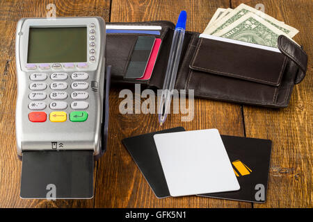 Wireless-Zahlterminal und Geldbeutel mit Dollar-Banknoten Stockfoto