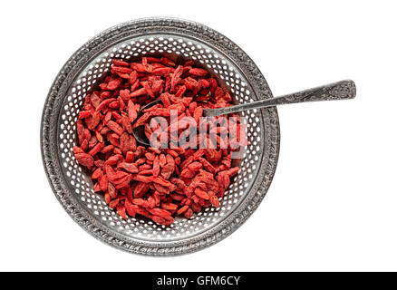 Antik Metall-Behälter der Rohe getrocknete Goji-Beeren mit Vintage teaspooned innen isoliert auf weiß Stockfoto