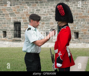 La Citadelle, Quebec, Kanada - Gardist im Dienst einen Bärenfell Hut gegeben ein Getränk mit einem Strohhalm an einem heißen Sommertag Stockfoto