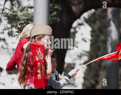 Junge Kinder mit Fahnen beobachten 9. Mai Tag des Sieges Parade 2016 Sewastopol Krim Stockfoto