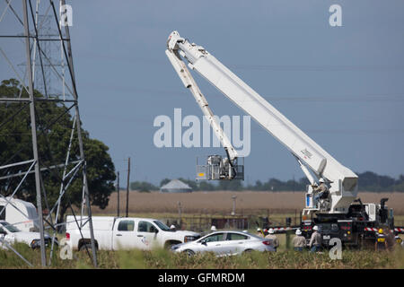 Lockhart, Texas, USA. 31. Juli 2016. Linemen und Beamten des Bundes National Transportation Safety Board (NTSB) Umfrage eine Texas-Heu-Feld und Stromleitungen, wo ein Heißluft-Ballon-Absturz Samstag 16 Menschen ums Leben. Berichte hatten die niedrig fliegenden Ballon möglicherweise schlagen Hochspannungsleitungen und Feuer fangen. Stockfoto