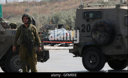 Nablus. 31. Juli 2016. Israelische Soldaten versammeln sich um ein Fahrzeug, ein palästinensischer Mann an einem Kontrollpunkt in der Nähe von West Bank Stadt von Nablus, am 31. Juli 2016 angehören. Israelische Sicherheitskräfte sagten, sie geschossen und getötet einem palästinensischen Knifeman, die versucht zu erstechen Soldaten an einem Checkpoint Westjordanland am Sonntag. © Ayman Nobani/Xinhua/Alamy Live-Nachrichten Stockfoto