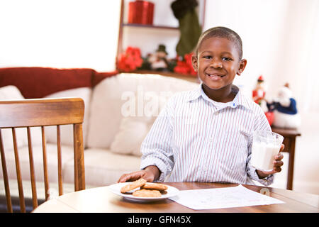 African American Mutter und Kind feiern Sie Weihnachten mit einem Weihnachtsbaum, Lebkuchenhaus und Geschenke. Stockfoto