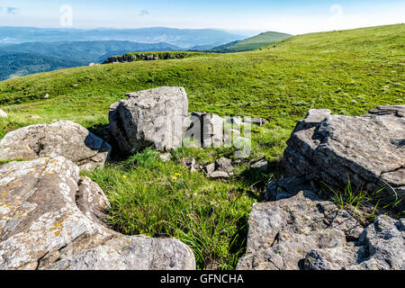 Berglandschaft mit Steinen Verlegung unter dem Rasen oben auf dem Hügel unter dem bewölkten Sommerhimmel Stockfoto