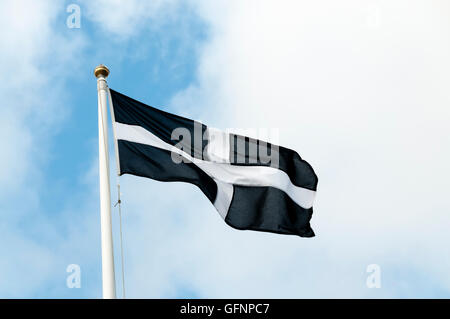 Das kornische Flagge hissen vor einem blauen Himmel. Stockfoto