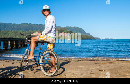 Touristen auf Fahrrad von Hanalei Pier auf Kauai Stockfoto