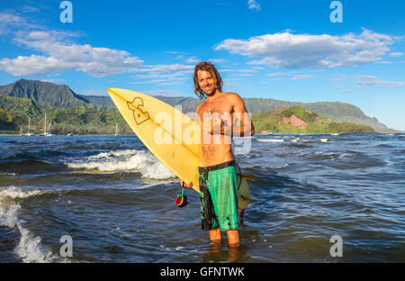 Surfer in Hanalei Bay auf Kauai mit Mt. Makana genannt Bali Hai in Ferne Stockfoto