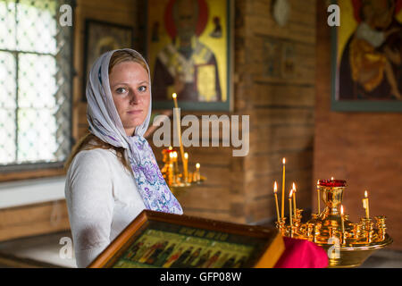 Junge Frau innerhalb der orthodoxen Kirche. Stockfoto