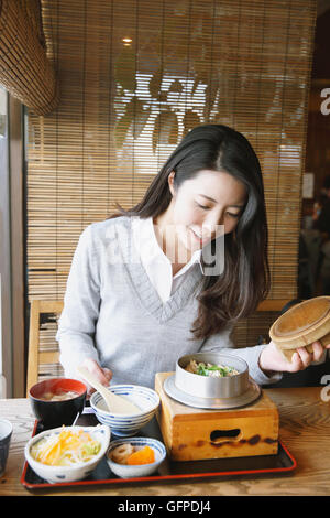 Junge attraktive Japanerin Essen im restaurant Stockfoto