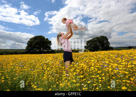 Eine junge Mutter und ihre Tochter genießen das warme Wetter diesen Sommer an der English Lavender Centre, Alton, Hampshire, UK. Stockfoto
