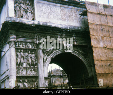 Dieses Foto, aufgenommen im Jahr 1970 zeigt Trajansbogen in Benevento (Benevent) in Süditalien, wenn es im Bau war. Der Bogen überspannt die Via Appia (Via Appia) auf ihren Einstieg in Benevento. Der Bogen wurde in 114 n. Chr. erbaut. Der Bogen wurde gebaut, um den Abschluss der Via Traiana, zu gedenken, die eine schnellere Route nach Rom als die Via Appia angeboten. Die Reliefs auf dem Bogen verherrlichen, Trajan und seine Leistungen, vor allem seine Eroberung neuer Ländereien. Ein wesentliches Merkmal der Reliefs sind die zahlreichen jungen Menschen dargestellt, einschließlich junger Menschen empfangen die grenadischer, dem Gemeinwohl Stockfoto