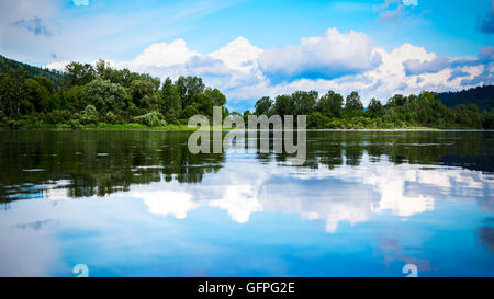 Schöne Landschaft Panorama mit blauen Wolkenhimmel spiegelt sich in dem klaren Wasser. Bewaldeten Ufer eines Bergsees. Stockfoto