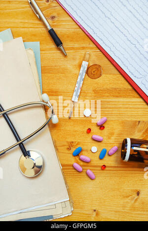 Bunte medizinische Tabletten und Pillen verstreut auf Schreibtisch des Arztes, Ansicht von oben Stockfoto