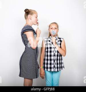 Zwei süße kleine Freundin Essen hell Lutscher. Lustige Kinder. Beste Freundinnen verwöhnen und posiert Stockfoto