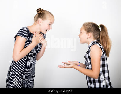 Zwei süße kleine Freundin mit dem Ausdruck ihrer verschiedene Emotionen. Lustige Kinder. Beste Freundinnen verwöhnen und posiert Stockfoto