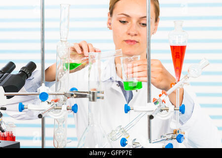 Chemisches Laboratorium Szene: attraktive junge Studentin Wissenschaftler beobachten die blaue Anzeige Farbverschiebung nach der Lösung Stockfoto