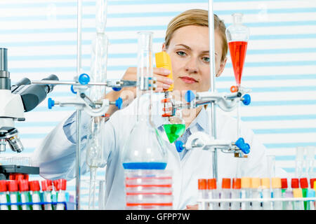 Chemisches Laboratorium Szene: attraktive junge Studentin Wissenschaftler beobachten die blaue Anzeige Farbverschiebung nach der Lösung Stockfoto