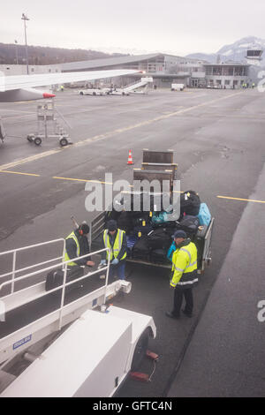 Gepäckabfertiger laden Gepäck auf dem Flugzeug am Flughafen Chambéry, Frankreich, Europa Stockfoto