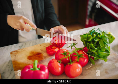 Eine Frau mit einem scharfen Messer schneiden Tomaten Stockfoto