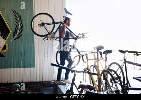 Ein Mann, der arbeitet in einer Fahrradwerkstatt Stockfoto